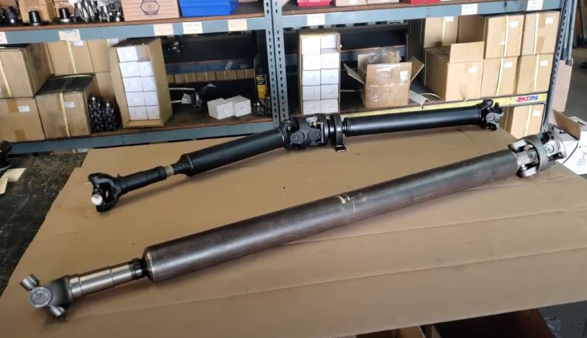 A gladiator 2 piece driveshaft next to a gladiator 1 piece drive shaft